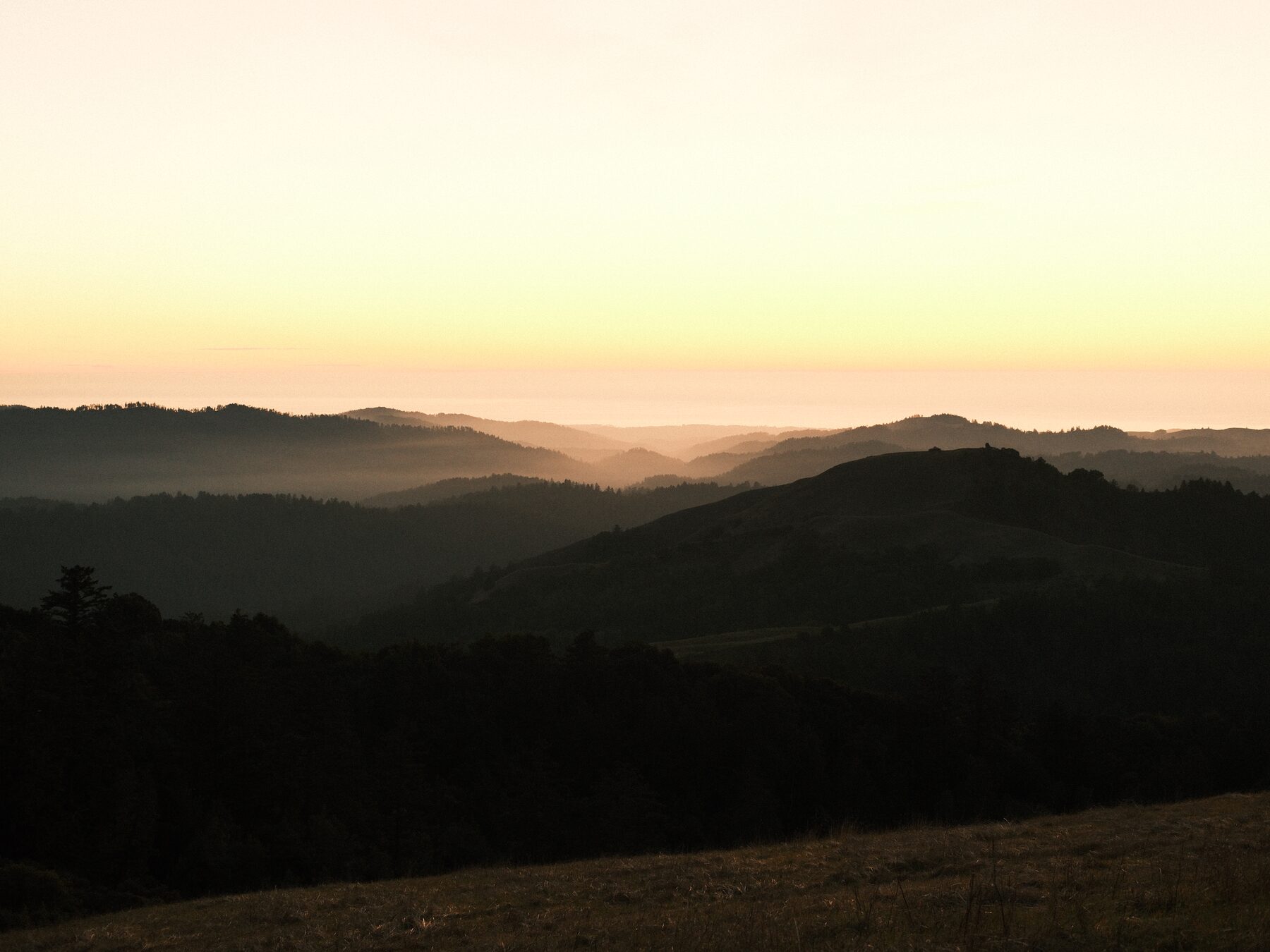 Layered ridgelines under an orange sky