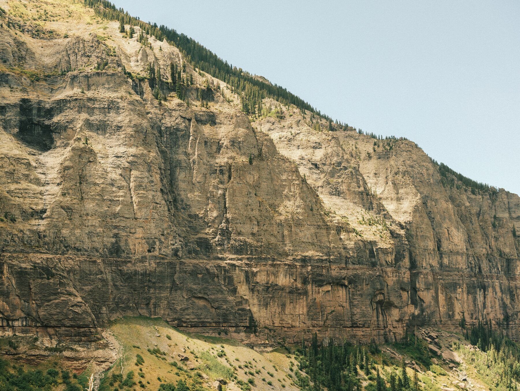 Layered cliff band with a road cut along its base